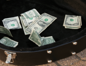 a suitcase filled with money sitting on top of a sidewalk